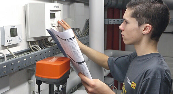 Ein Elektroniker-Auszubildender konfiguriert einen W&auml;rmepumpen-Manager
