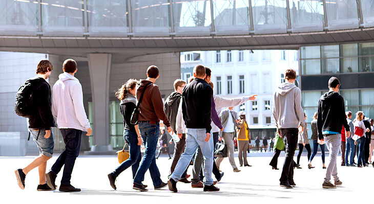 Das Bild zeigt eine gro&szlig;e Gruppe Jugendlicher, die &uuml;ber einen &ouml;ffentlichen Platz laufen.